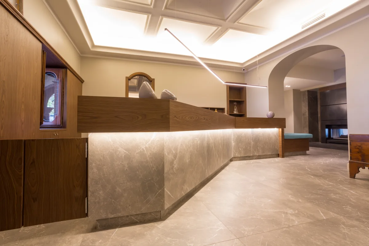 Reception moderna dell'hotel con bancone in marmo e legno e illuminazione soffusa