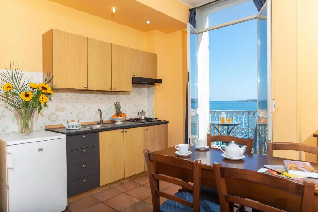 Cucina dell'appartamento con tavolo e balcone con vista mare