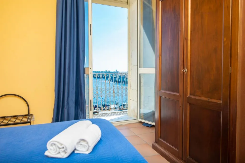 Camera da letto con armadio in legno e balcone affacciato sul mare
