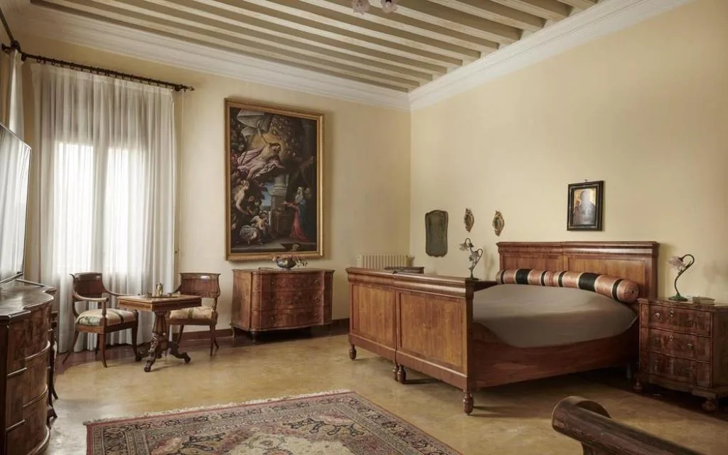 Camera signorile con letto in legno pregiato, dipinto antico e mobili d'epoca