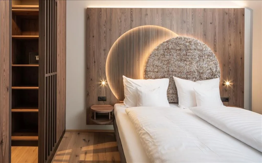 Camera con letto matrimoniale, testiera illuminata e cabina armadio in legno