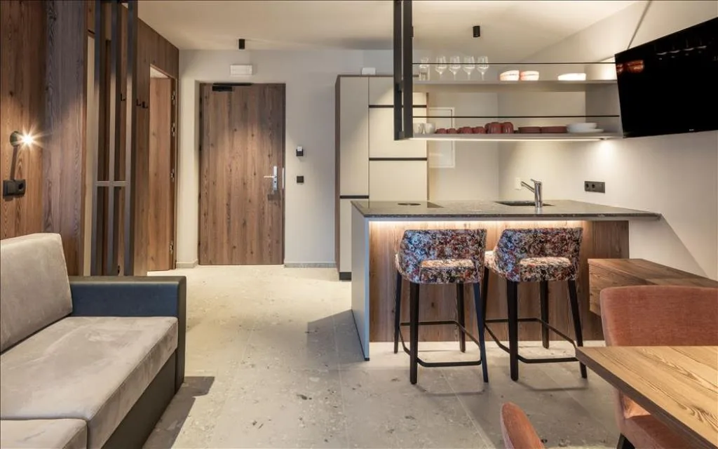 Soggiorno open space con cucina, isola con sgabelli e divano