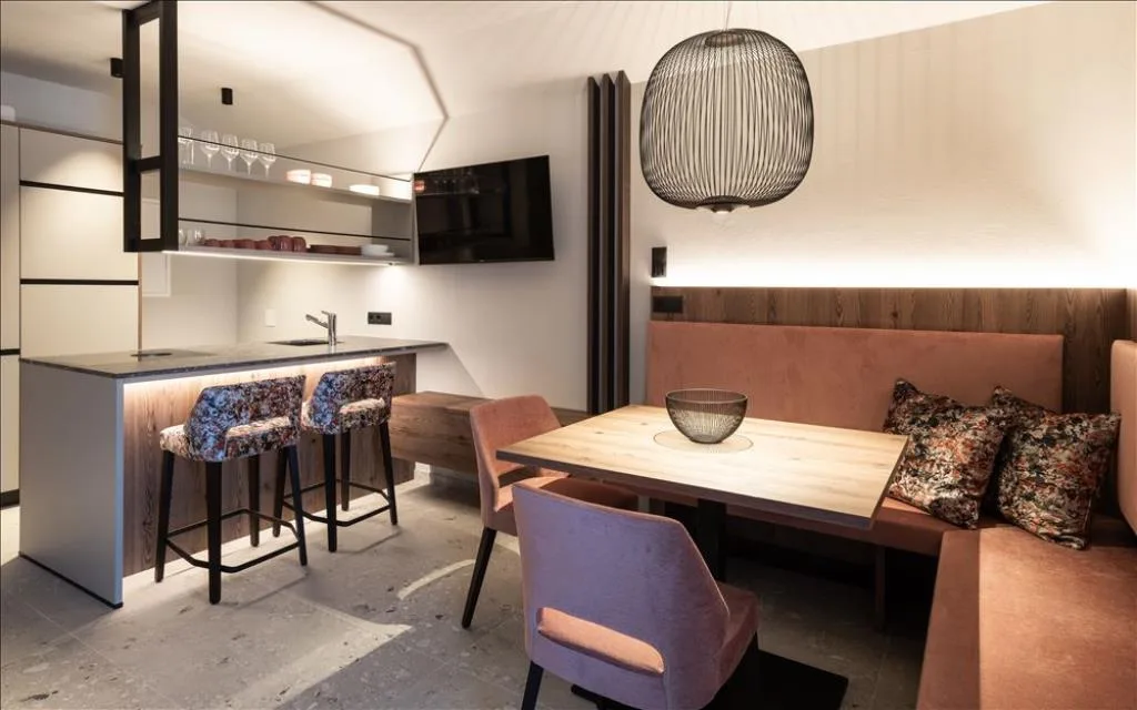 Zona living con cucina moderna, tavolo da pranzo e panca imbottita
