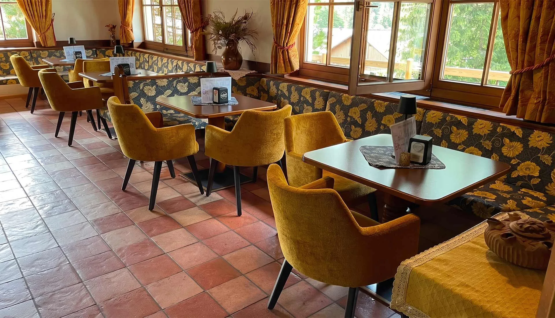 Sala da pranzo con poltrone gialle e pareti con motivi floreali