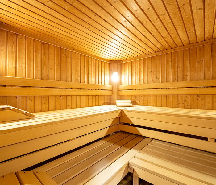 Sauna finlandese in legno con panche e illuminazione soffusa