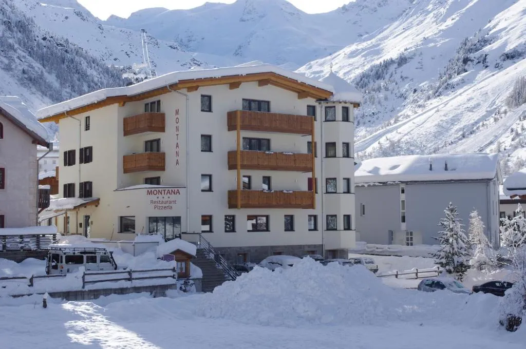 Hotel Montana in paesaggio invernale con abbondante neve e vette alpine imbiancate