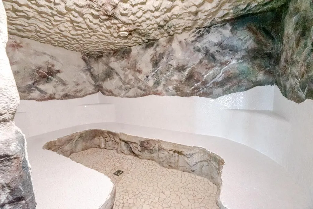Grotta relax della spa con pareti effetto roccia e panca in pietra