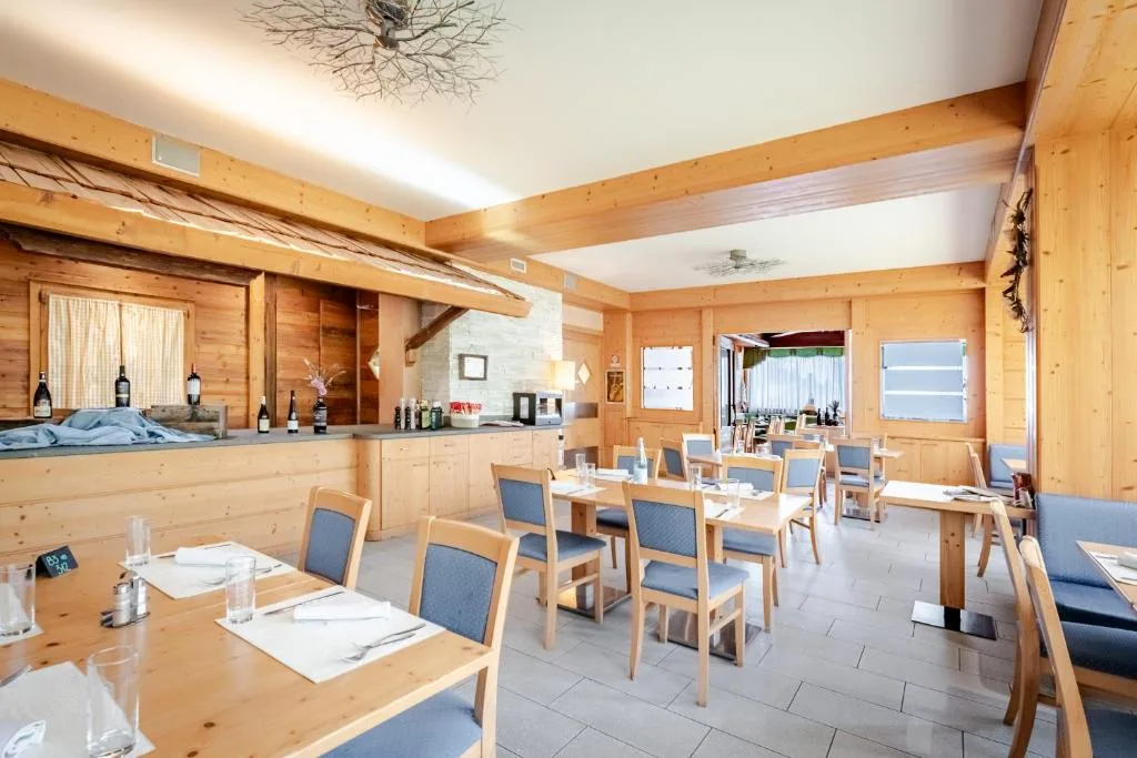 Ristorante rivestito in legno con tavoli apparecchiati e sedute blu