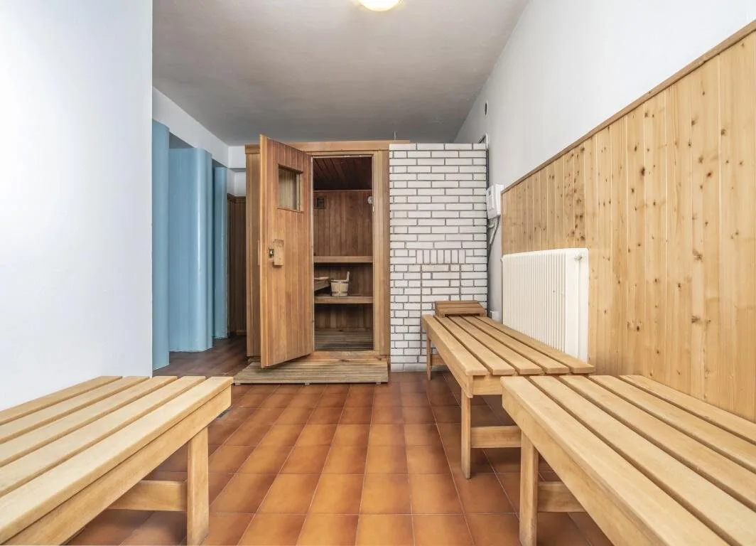 Area sauna con panche in legno e rivestimenti in mattoni