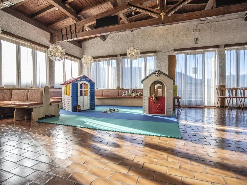 Sala con grandi finestre e area giochi per bambini con casette