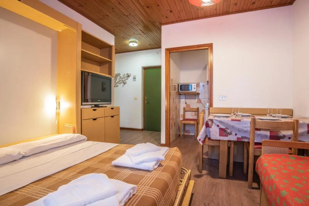 Camera con letto matrimoniale, angolo cottura e zona pranzo