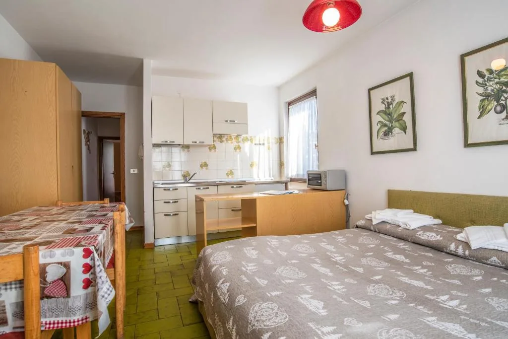 Monolocale con letto matrimoniale, cucina attrezzata e tavolo da pranzo