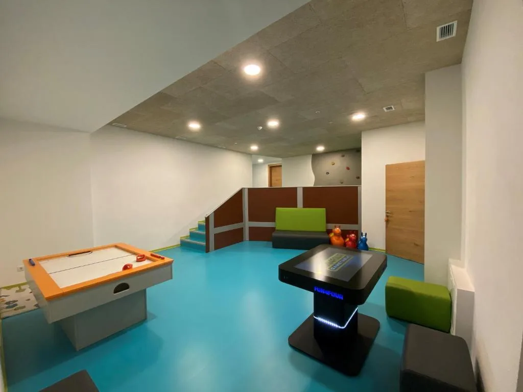 Sala giochi per ragazzi con air hockey, gioco elettronico interattivo e parete da arrampicata