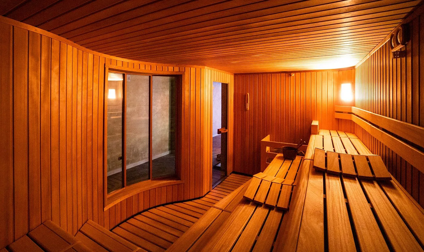 Interno della sauna finlandese in legno con panche e specchio