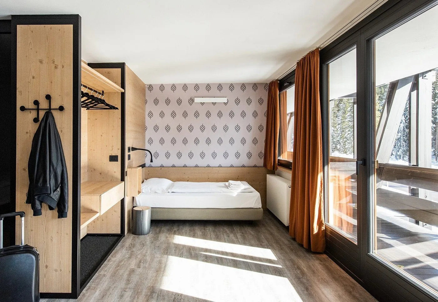 Camera moderna con guardaroba in legno, letto singolo e grandi vetrate