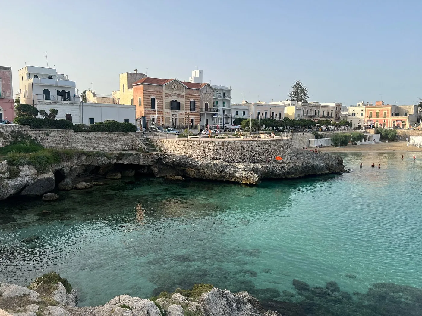 Vista della costa con baia, acque cristalline e edifici sul lungomare