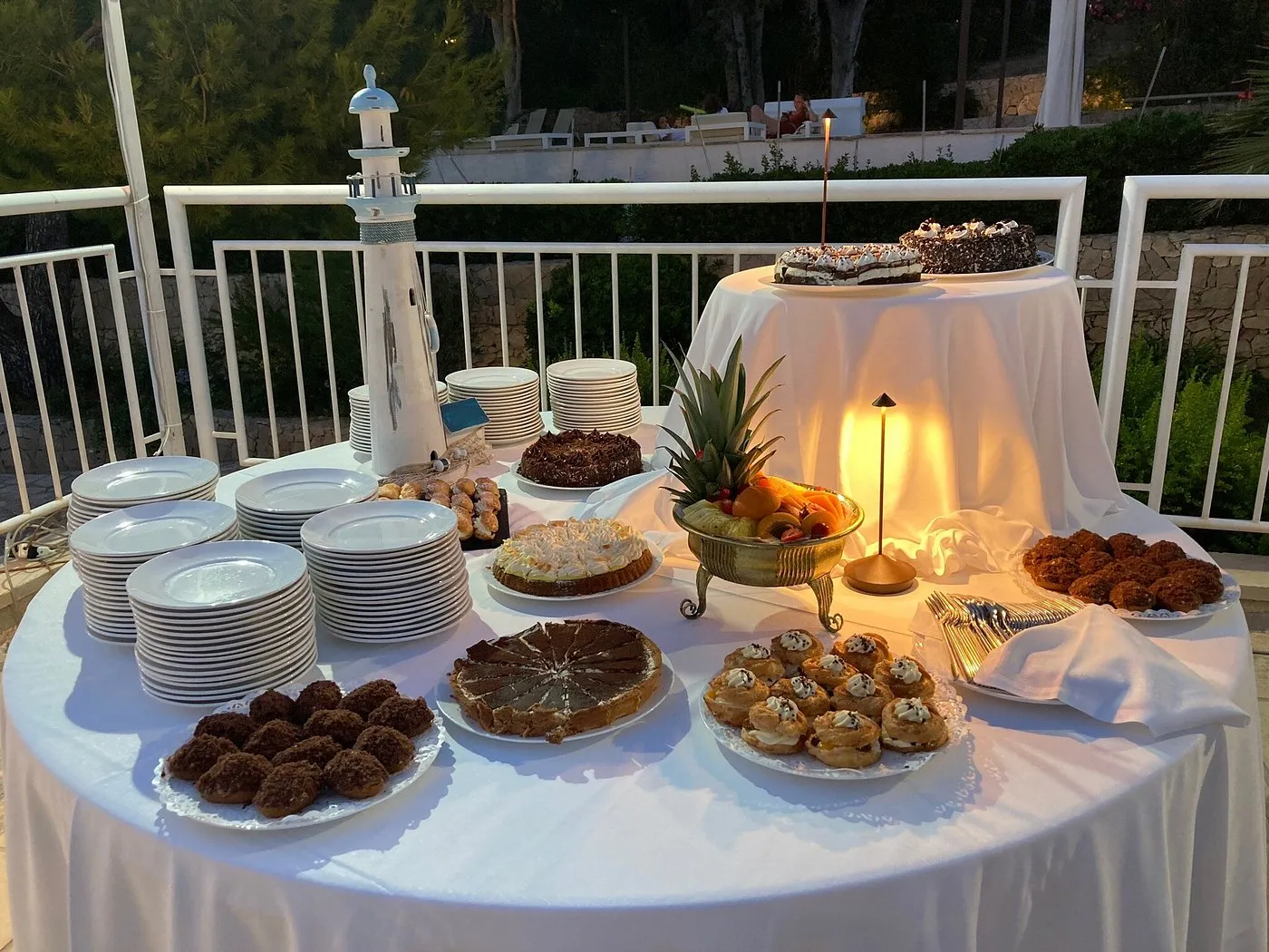 Tavolo buffet di dolci all'aperto al tramonto con torte e pasticcini