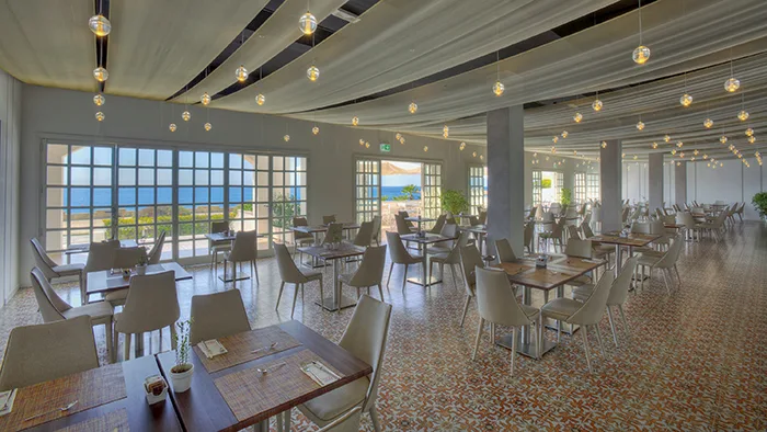 Sala ristorante moderna con grandi finestre e vista sul mare
