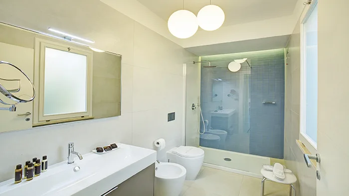 Bagno moderno con doccia in vetro, doppio lavabo e specchio illuminato