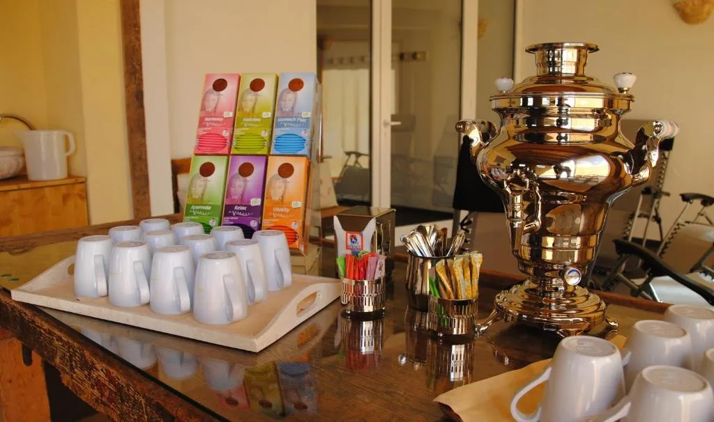 Angolo tisaneria con samovar dorato, tazze e assortimento di tè