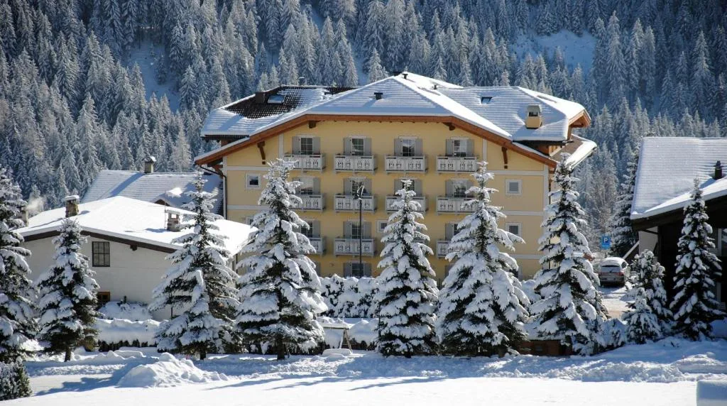 Hotel innevato circondato da abeti coperti di neve nel paesaggio invernale