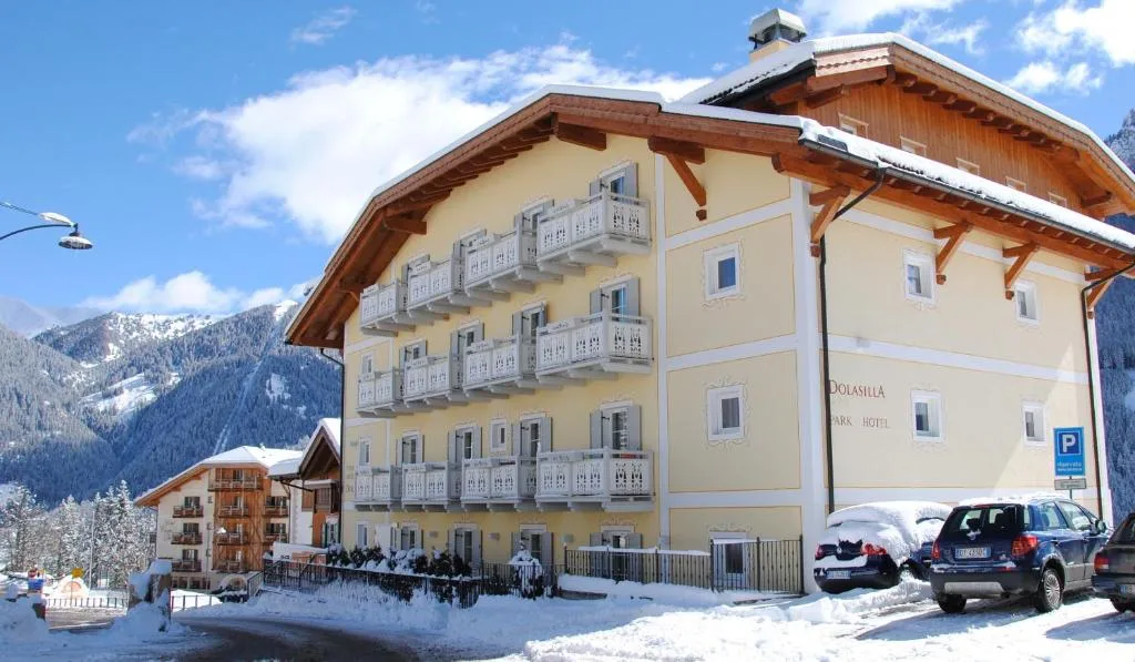 Esterno dell'hotel Dolasilla con neve e balconi in legno in inverno
