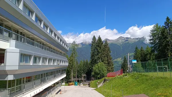 Lato dell'edificio con vista panoramica sulle montagne e abeti