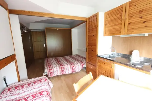 Monolocale con angolo cottura in legno, letti e zona pranzo