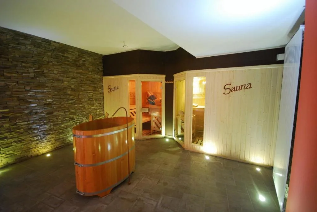 Area saune in legno con botte e pareti in pietra