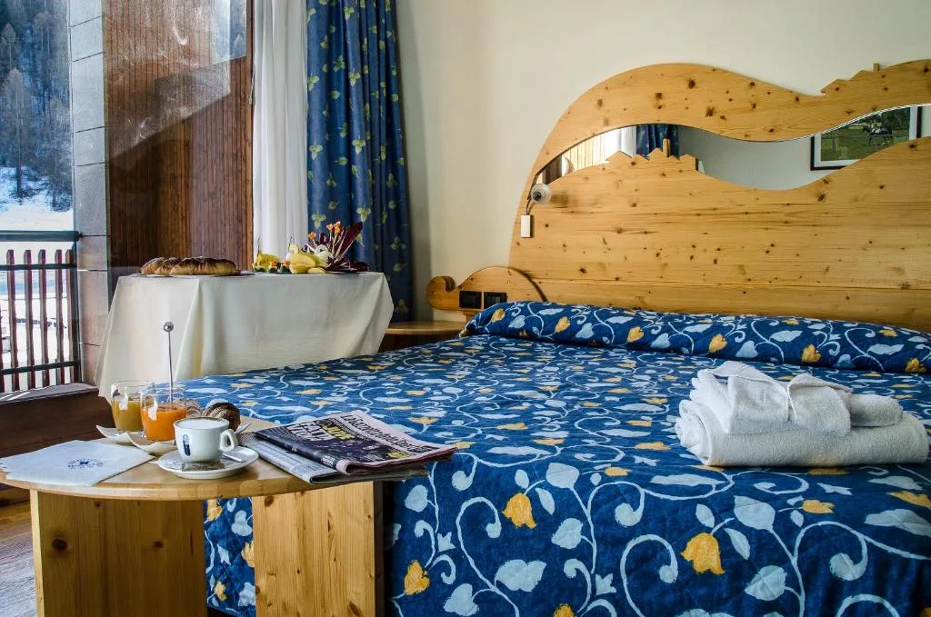 Letto matrimoniale con testiera in legno e colazione con vista