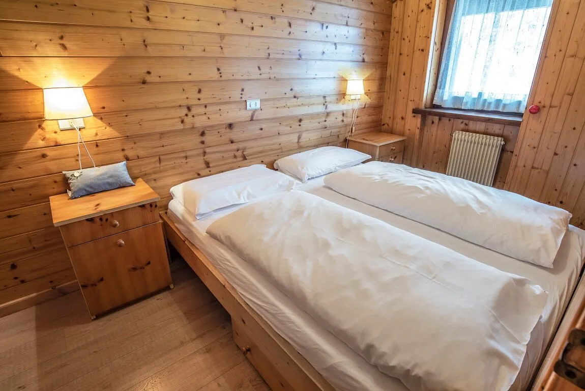 Camera con letto matrimoniale e pareti rivestite in legno