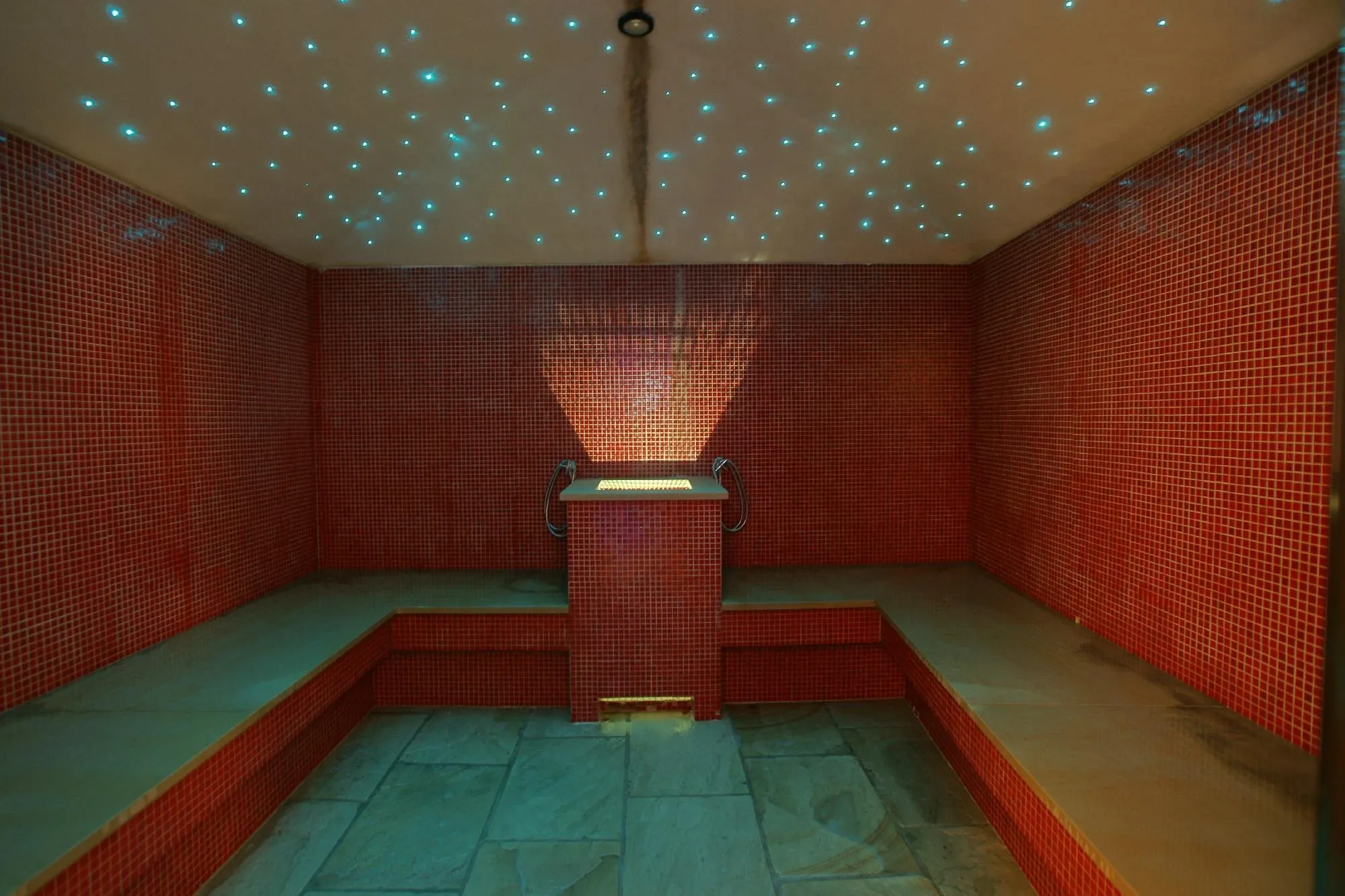 Bagno turco con mosaico rosso e soffitto illuminato a cielo stellato
