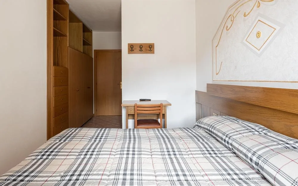 Camera con letto matrimoniale, scrivania e armadio in legno