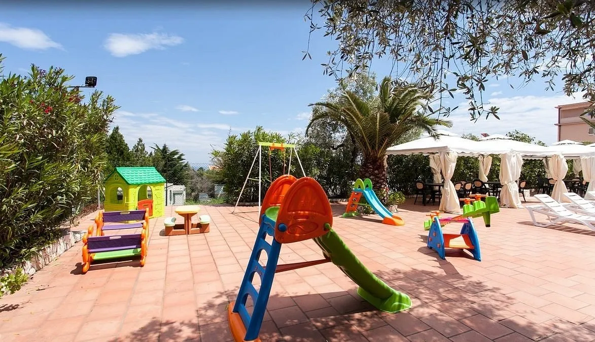 Area giochi per bambini all'aperto con scivoli e casetta colorata