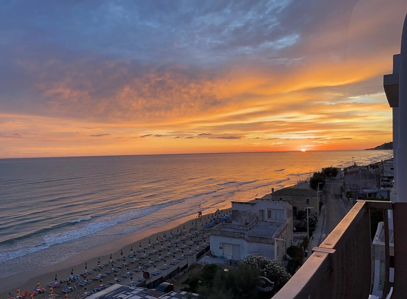 Tramonto sul mare con vista panoramica sulla spiaggia e la costa