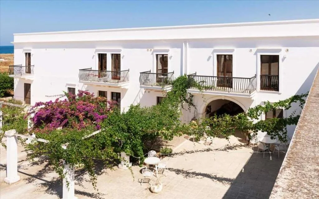 Cortile interno con vegetazione, bouganville e vista mare sullo sfondo