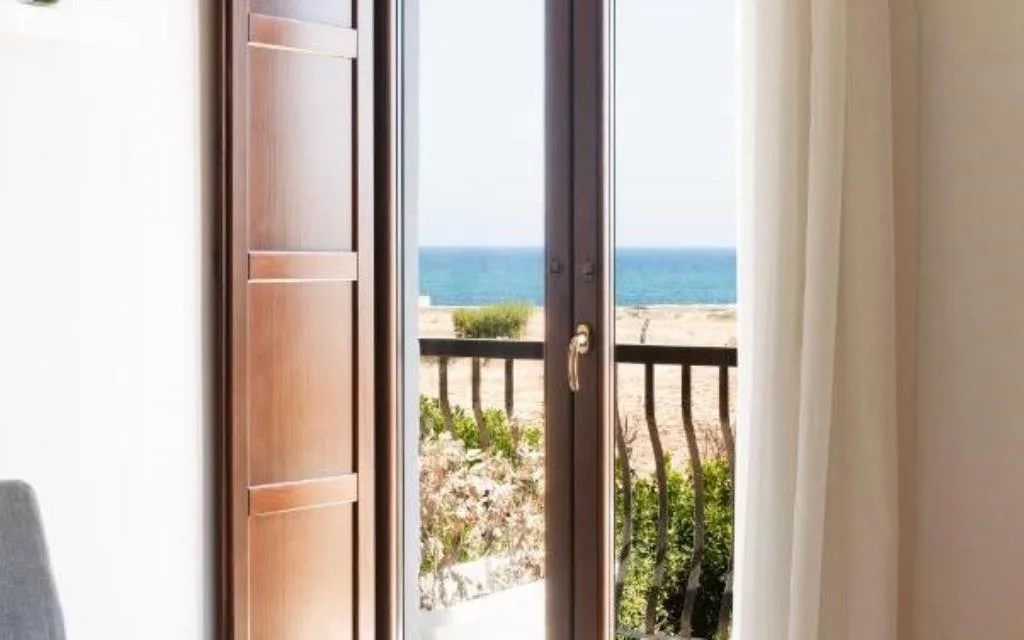 Porta finestra con vista sul mare e sulla spiaggia dalla camera