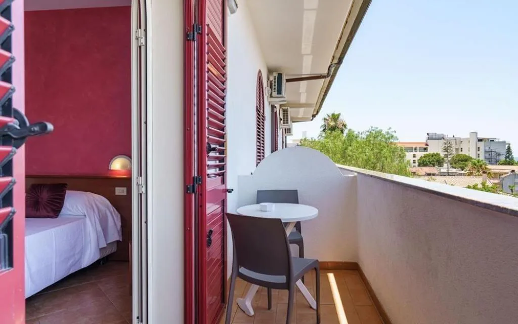 Balcone privato con tavolino, sedie e vista sul verde circostante