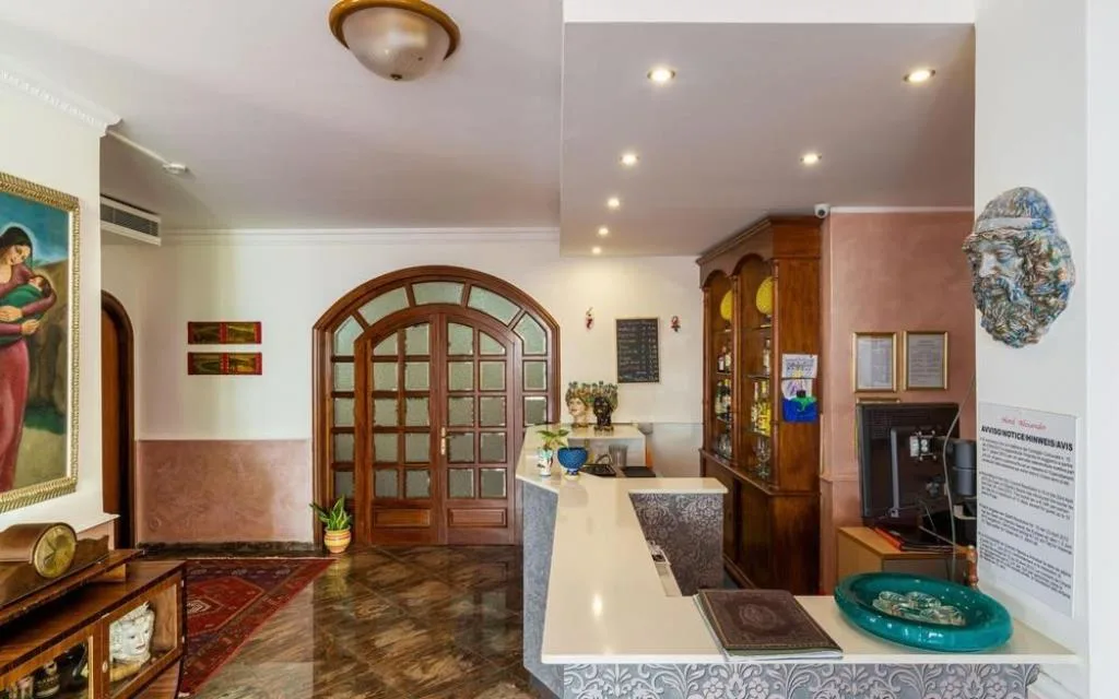 Reception con porta a vetri ad arco in legno e dettagli decorativi siciliani