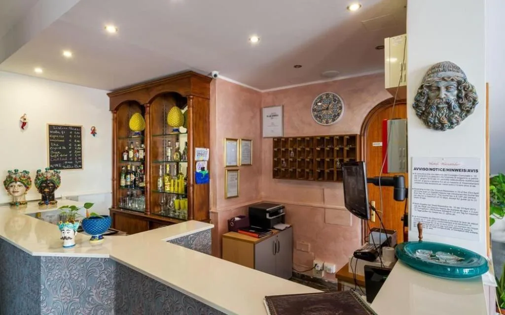Area bar della reception con espositore di liquori e teste di moro in ceramica