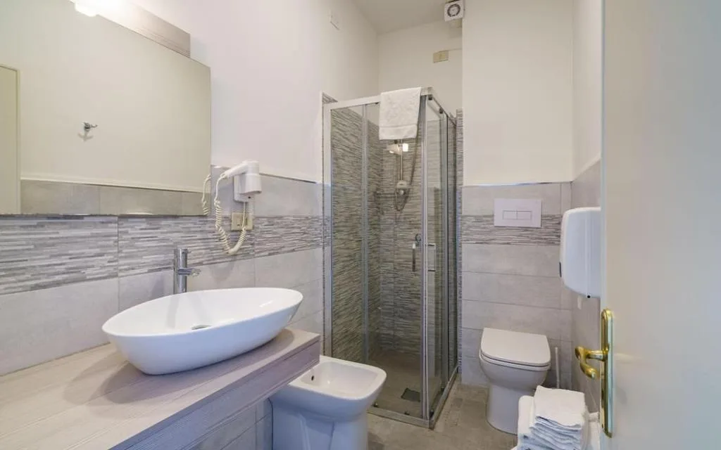 Bagno moderno con doccia, lavabo, bidet e piastrelle grigie