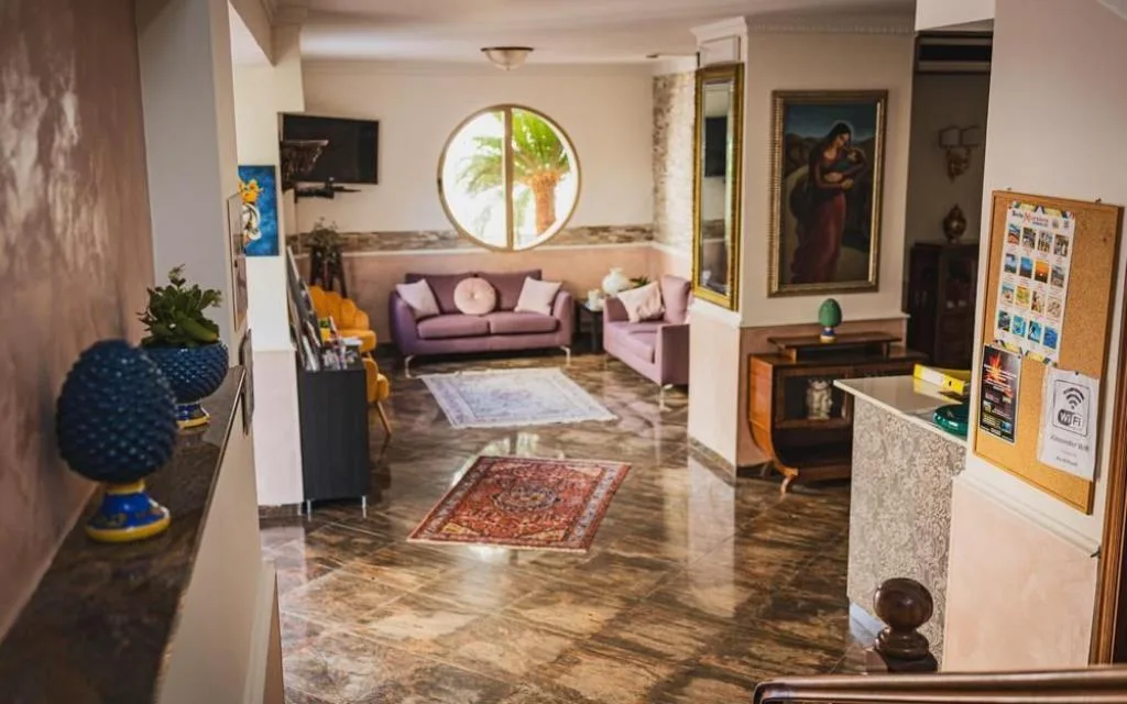 Hall elegante con divani viola, finestra rotonda e pavimento in marmo