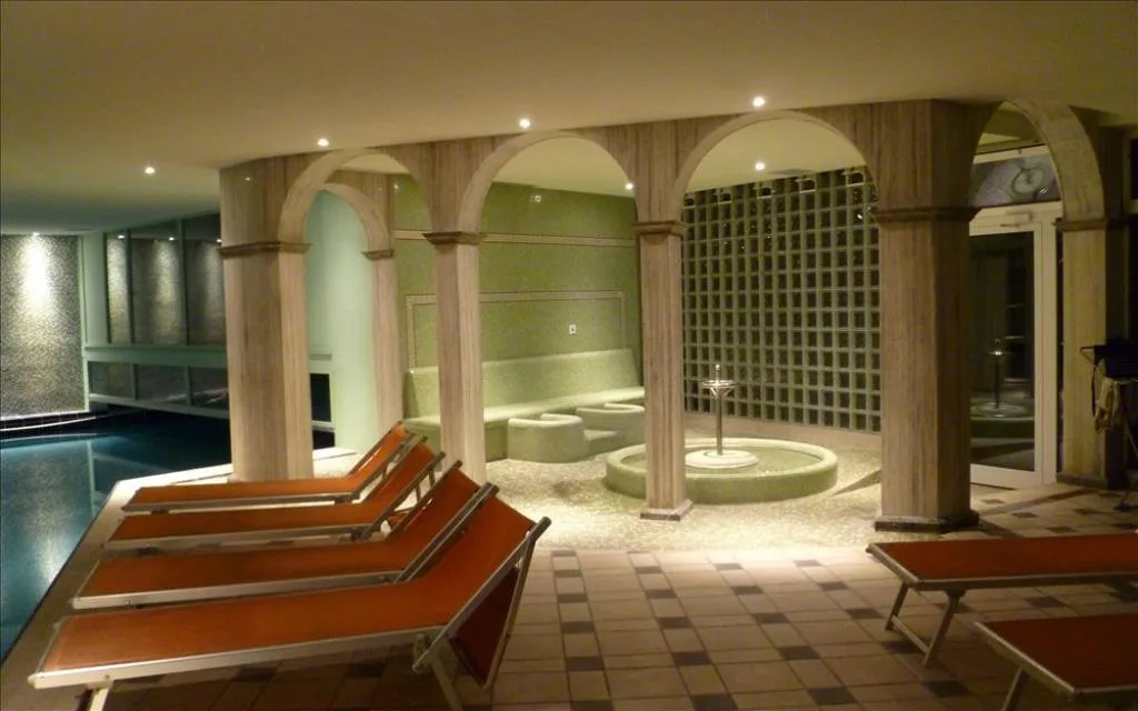 Area relax della spa con lettini, colonne ad arco e fontana illuminata
