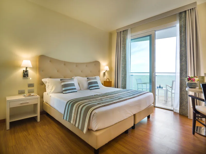 Camera matrimoniale con letto, balcone e vista mare