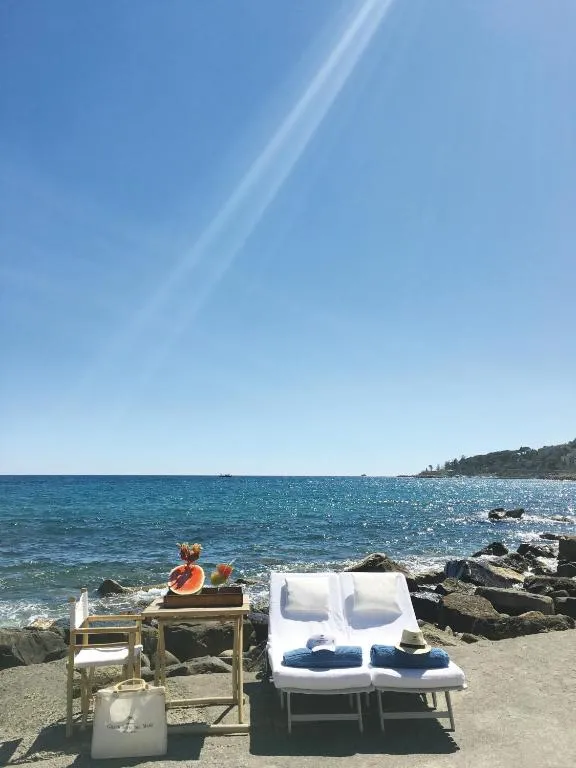 Lettini con asciugamani e vassoio di frutta in riva al mare sotto il sole