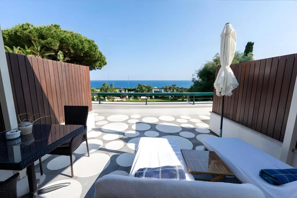 Terrazza privata con lettino, tavolo e ombrellone affacciata sul giardino e mare