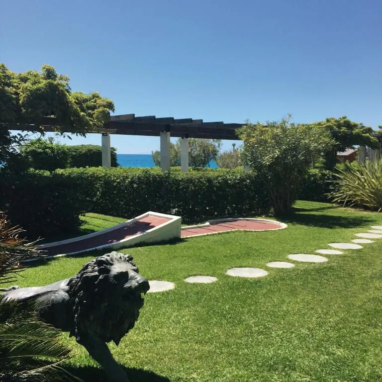 Giardino con minigolf, statua di leone e vista sul mare
