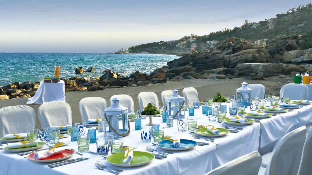 Tavolo elegantemente apparecchiato in riva al mare sulla spiaggia
