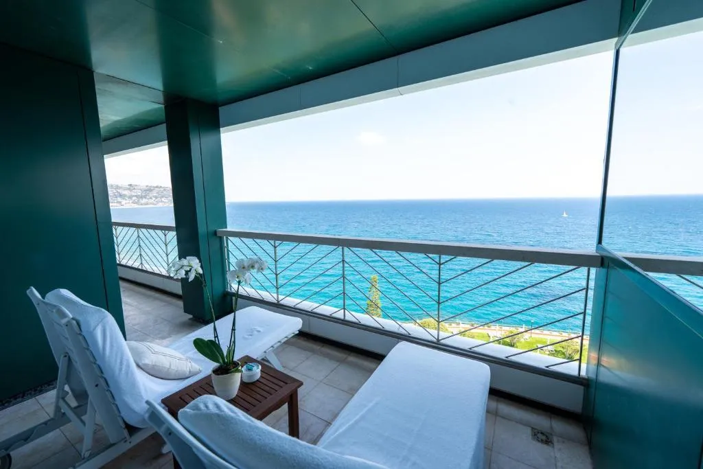 Balcone con lettini bianchi e vista panoramica sul mare turchese