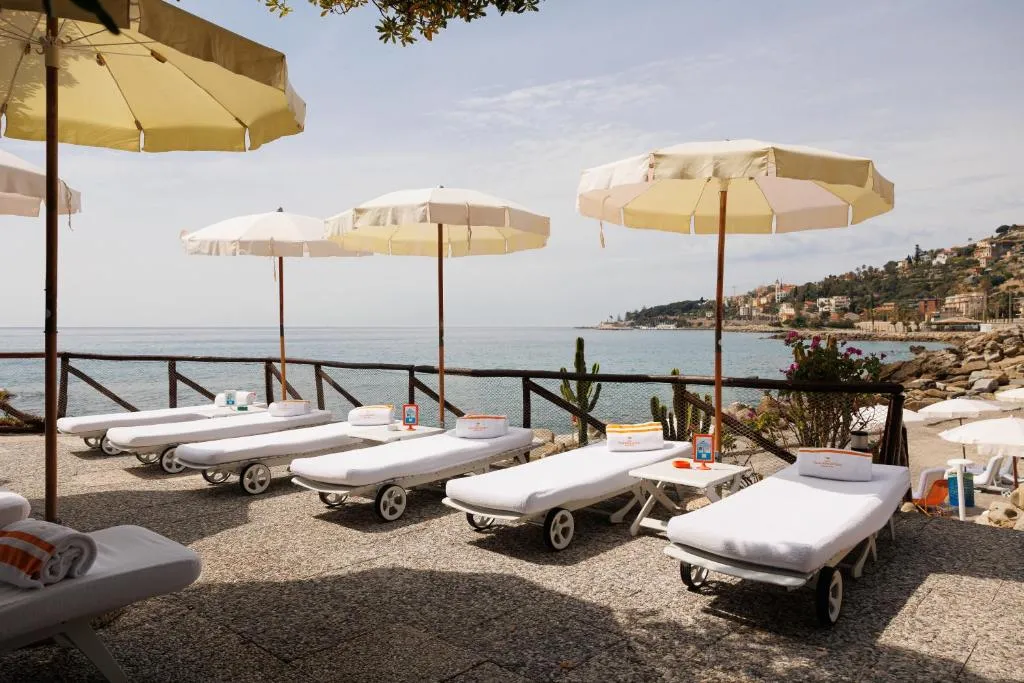 Lettini con ombrelloni e asciugamani affacciati sul mare della riviera
